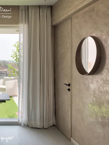 A detail from the Agra Fort Project bedroom, showing the textured lime plaster wall and a simple, elegant mirror. The door leads out to the terrace, reinforcing the connection between the indoor and outdoor spaces.