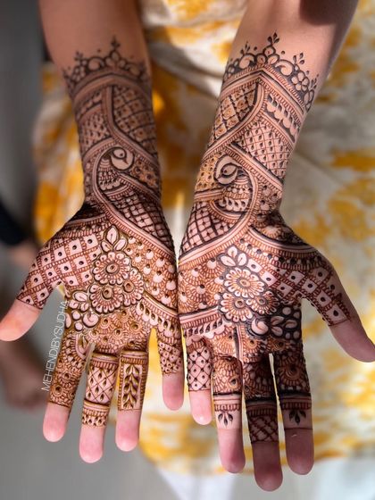 The design shown against a yellow background, highlighting the rich color of the henna.