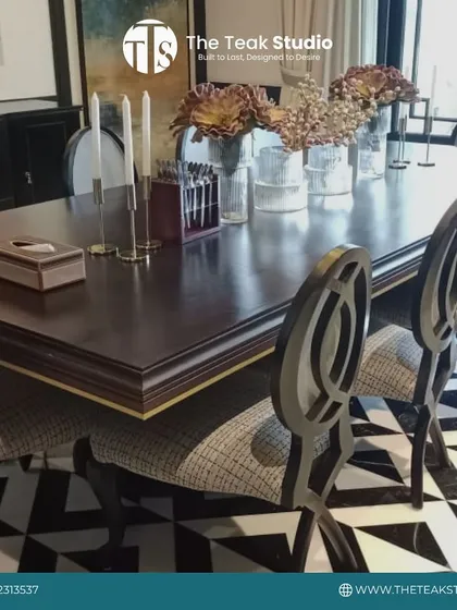 This formal dining set makes a bold statement with its high-gloss PU finish on a dark wood table. The unique, artistically designed chair backs and the striking black-and-white geometric flooring create a truly opulent dining experience.