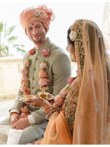 A candid moment during the ceremony, filled with smiles and tradition. The groom's happy expression is priceless.