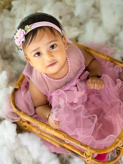 An intimate, close-up portrait of a toddler girl looking up from her basket, highlighting her expressive eyes.