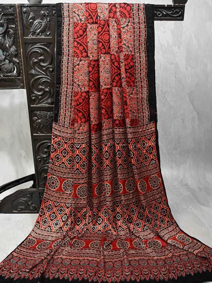 A striking red and black block-printed saree with intricate geometric patterns. This is a bold and artistic piece that is sure to make a statement.