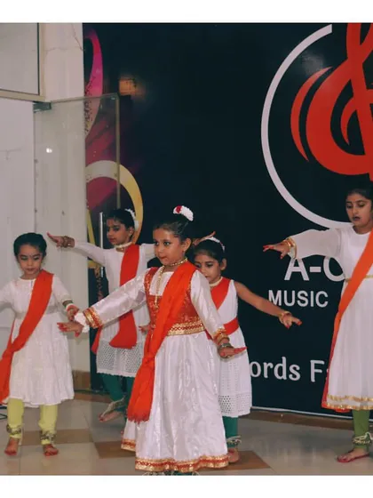 A group of our Kathak students performing in white and red, representing a blend of classical dance and festive celebration.
