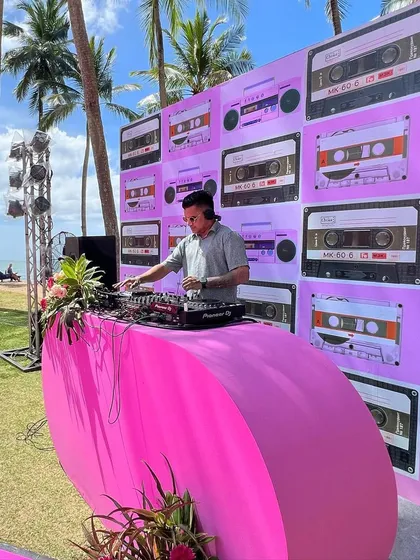 A retro-themed beach party in Phuket, Thailand. The cassette tape backdrop and bright pink console created a fun, nostalgic vibe.