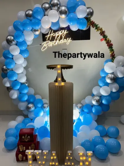 A simple and chic ring decoration with blue and white balloons. The single pedestal with a light-up number "1" is perfect for a minimalist first birthday.