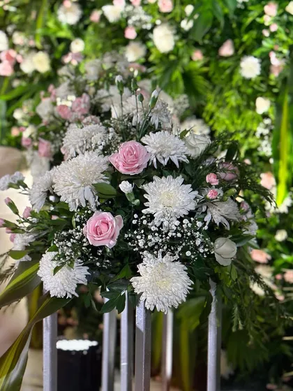 The details are what make an event special. This is a close-up of a floral arrangement with delicate pink roses and white chrysanthemums, showcasing the quality and freshness of the flowers I use in my decor.