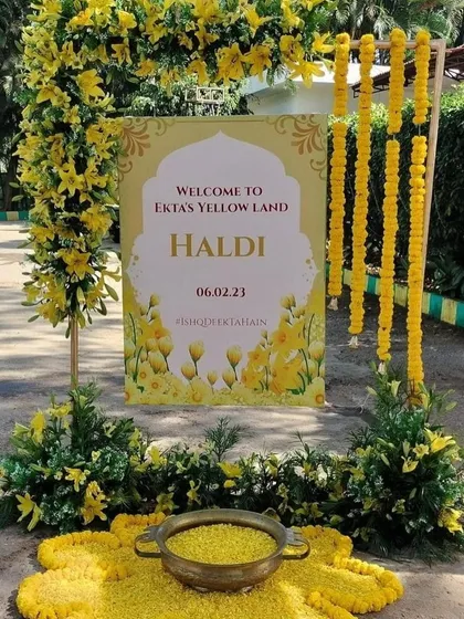 "Welcome to Ekta's Yellow Land." A personalized welcome sign like this makes the event feel truly special. I framed it with yellow flowers and marigold strings to match the theme.