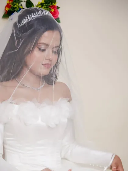 A soft and dreamy portrait of the bride under her veil. The off-shoulder satin gown and delicate tiara give her a classic, fairytale princess look.