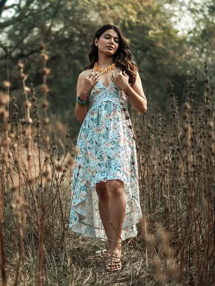 A full-length view shows how the dress and accessories come together. This image captures the complete look, from the necklace down to the sandals, providing a comprehensive view for a brand lookbook or style feature.