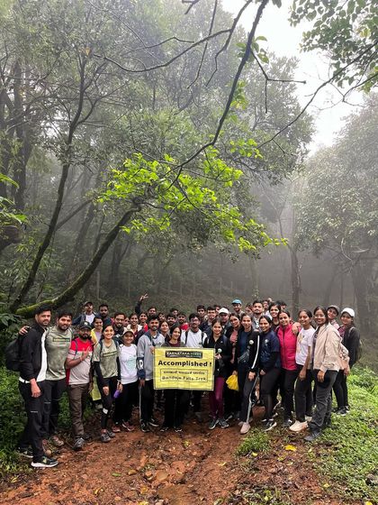 Our group in the misty forest, proudly holding the "Accomplished" banner after the Bandaje trek.