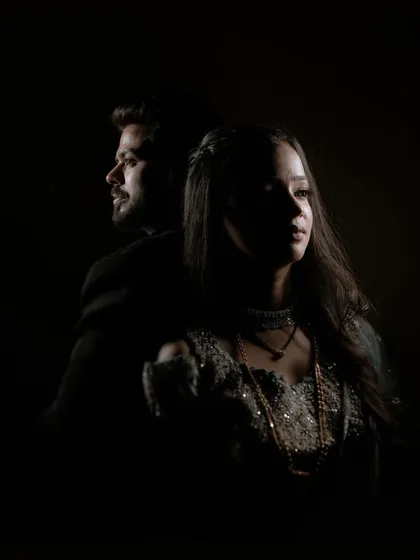 A moody and dramatic sangeet portrait using low-key lighting to create a sense of intimacy and artistry. This style is for couples who want their pre-wedding photos to feel like a piece of fine art.
