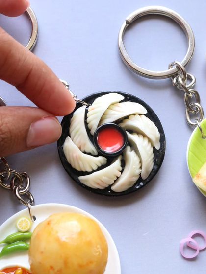 A close-up of a momo keychain, showing the delicate folds of the dumplings.