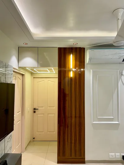 A clever way to add storage is by using the loft space above doors, concealed with a panel that matches the room's decor.