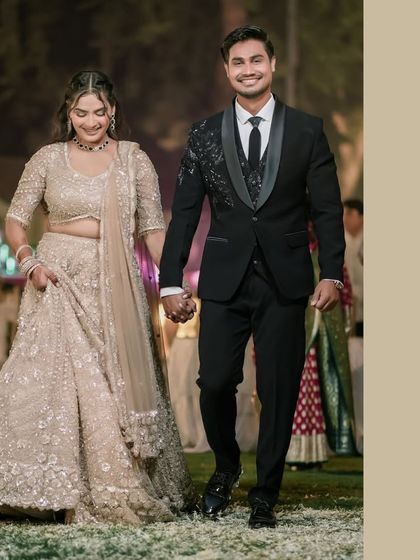 "Perfectly Us." The couple walks down a petal-strewn path, hand in hand, radiating happiness. This image captures the joy of starting their journey together.