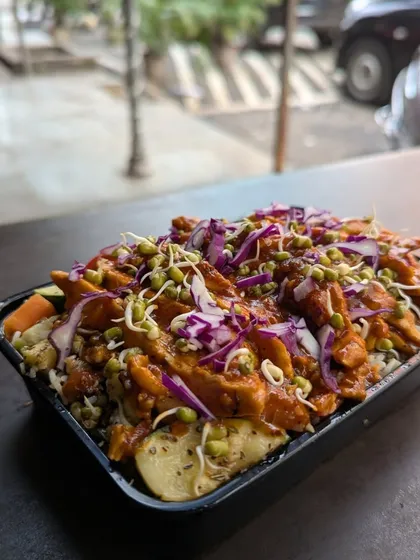 This packed salad bowl is a perfect example of how I combine textures and flavors. It features a base of fresh vegetables and grains, topped with chicken, red cabbage, and sprouted beans for extra crunch and nutrition.