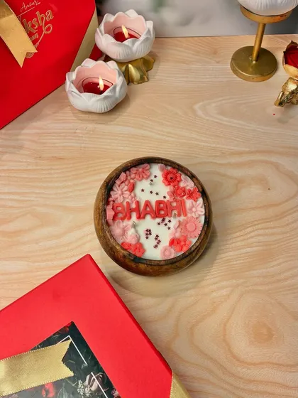 Celebrating the wonderful bond with your sister-in-law. This 'Bhabhi' candle is adorned with delicate pink and red flowers, a perfect way to make her feel special this Rakhi.