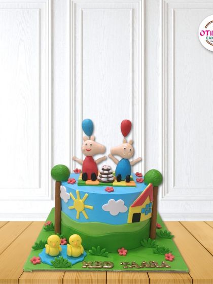 We brought Peppa Pig's world to life with this playful fondant cake. It features Peppa and George with their balloons, surrounded by a sunny landscape with trees, ducks, and their little house.