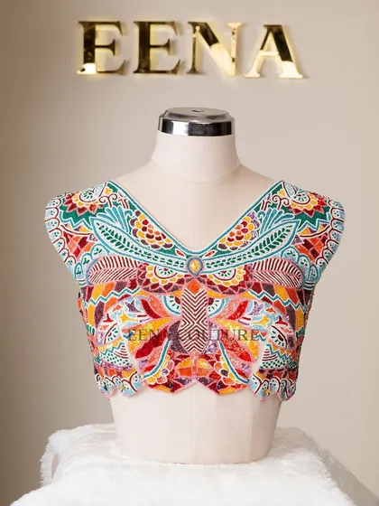 I designed this unique 'Butterfly Garden' blouse for the bride who loves color and artistry. The entire piece is covered in a vibrant mosaic of multi-colored beads and sequins, forming a stunning butterfly motif across the back.