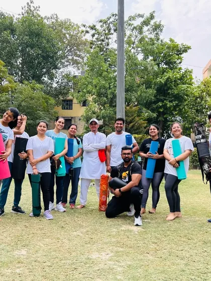 A happy group photo at the end of a session, with everyone holding their yoga mats. This captures the sense of accomplishment and community.