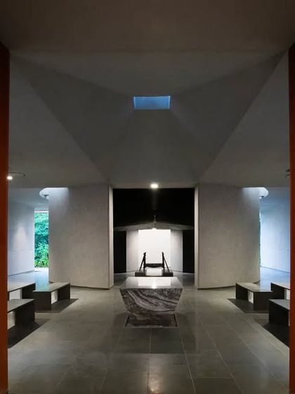 In a space designed for remembrance and quietude, a central skylight creates a focal point. The symmetrical design and controlled use of light foster a serene, contemplative atmosphere.