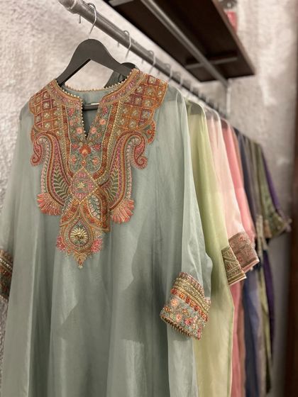 A stunning pastel blue kurta with heavy, multi-colored embroidery on the neckline and cuffs, a true statement of artistry.