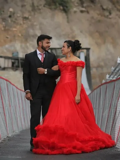 A stunning shot on a suspension bridge, with the bride in a flowing red gown creating a beautiful contrast with the natural surroundings.
