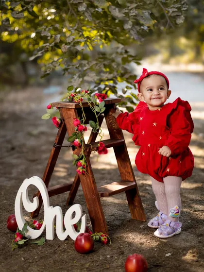 Celebrating one year with a rustic outdoor setup. The wooden ladder, apples, and 'One' sign create a charming and timeless look.