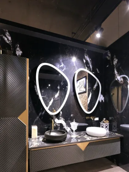 This vanity design for the Fima showroom is a statement in modern luxury. I contrasted dramatic black marble walls with custom back-lit asymmetric mirrors and gold fixtures to create a high-impact display that showcases the product in a bold, aspirational setting.