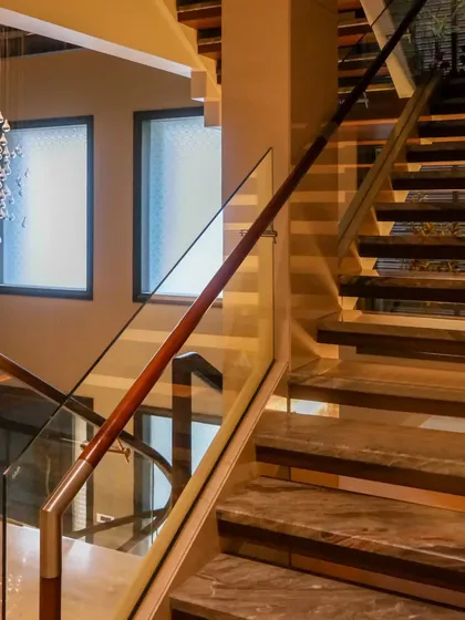 Staircases are a central feature that can transform a space. This design combines elegant materials and a dramatic chandelier to enhance the overall aesthetic of the home.