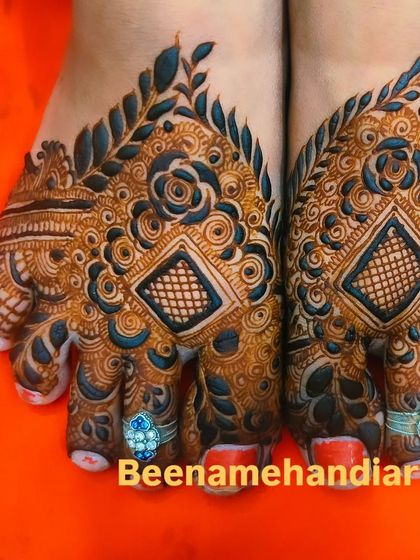 An intricate and unique foot mehandi design with geometric and floral elements. The use of color makes it stand out.