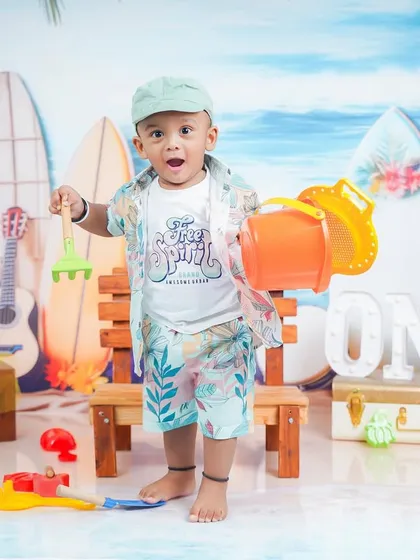 The excitement is real. This shot captures a moment of pure joy as he plays with the beach toys.