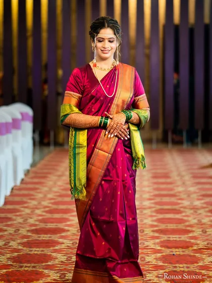 A full-length view of her walking down the aisle. The vibrant saree and traditional jewellery are perfectly balanced with a fresh and radiant makeup look.