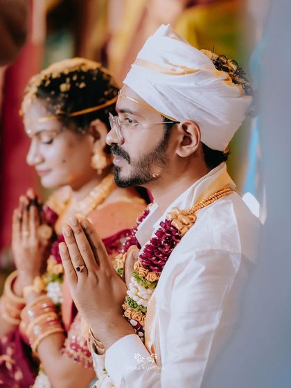 A close-up of the couple in prayer, their hands joined in reverence during their wedding ceremony.