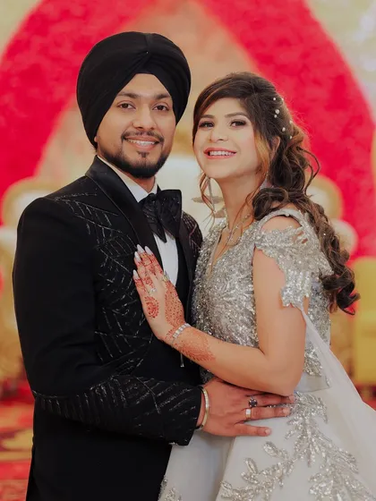 A beautiful portrait of the newly engaged couple, smiling for the camera. This shot captures their happiness against the vibrant floral stage decor.