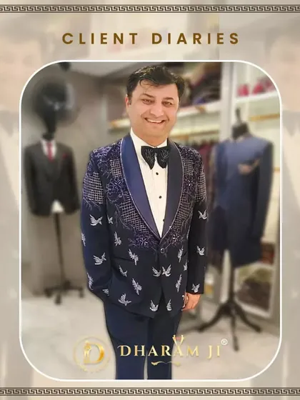 A client smiling in his custom-made navy blue tuxedo, which features sparkling lapels and a unique butterfly embroidery.
