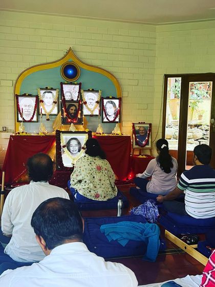 Devotees meditating in front of the altar, their focus directed inward. The practice of meditation is the foundation for experiencing the truths that our gurus have taught.