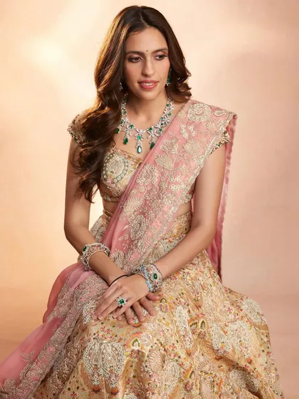 A closer look at the delicate embroidery and emerald jewelry paired with this Anamika Khanna lehenga. The styling creates a look of understated royalty.