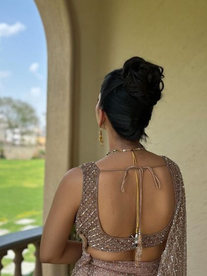 The back view of this sculpted updo shows the clean, tucked-in bun. This demonstrates the importance of a polished finish, even in a more avant-garde hairstyle.