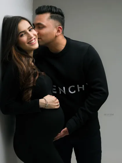 A sweet kiss on the cheek. This classic pose is always filled with warmth and affection, making it a favorite for couple's maternity photography.