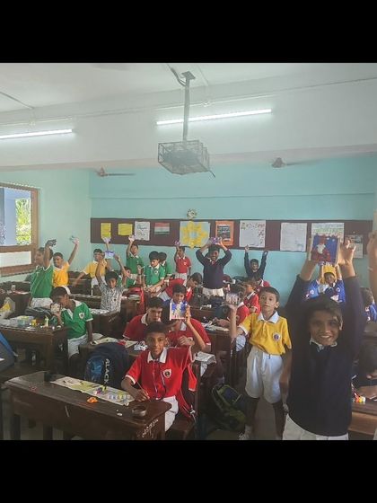 A classroom full of happy students holding up their creations at the end of our clay workshop. Their excitement is the best reward.