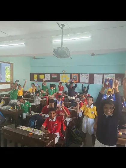 A classroom full of happy students holding up their creations at the end of our clay workshop. Their excitement is the best reward.