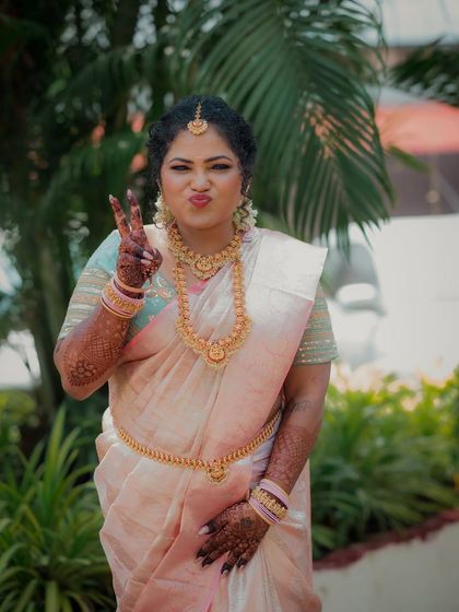 A fun and playful portrait of a beautiful South Indian bride at her engagement ceremony in Vashi. Her vibrant personality shines through as she makes a peace sign for the camera.