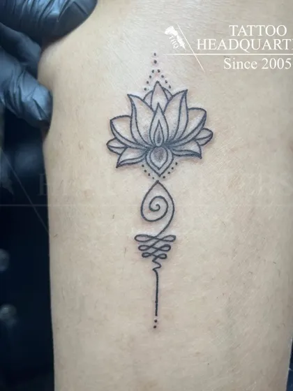 A Unalome tattoo with a lotus flower, a powerful symbol of the journey to enlightenment.