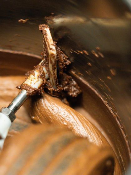 The mesmerizing process of grinding cacao nibs into a smooth, flowing chocolate liquor in a melanger.