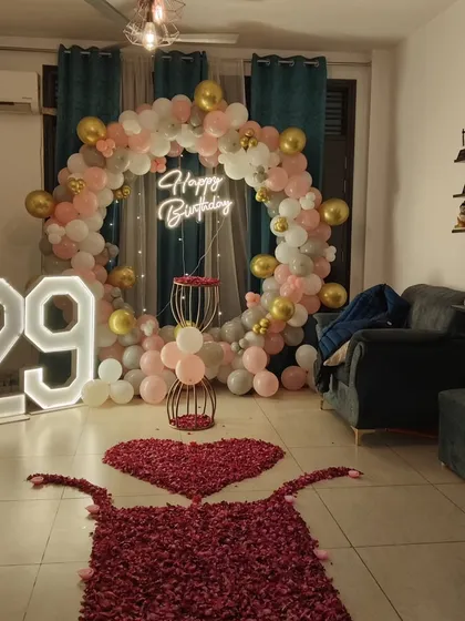 A wider view of the 29th birthday living room decoration, showing how the balloon arch and rose petal path work together to transform the space.