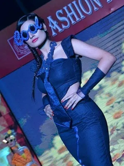 A student's design featuring a structured, form-fitting denim dress. This piece demonstrates skill in pattern making and creating tailored garments with unique cut-outs and details.