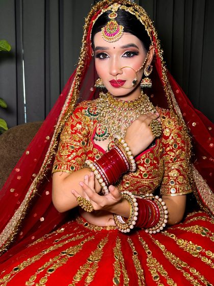 A classic bridal pose, with the bride looking at the camera. Her makeup is bold and beautiful, perfect for a traditional wedding.