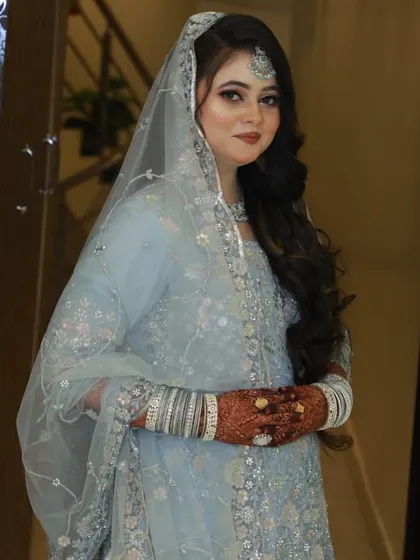 A full view of her elegant pastel blue look.