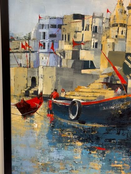 An angled shot of the 'Banaras Ghat' painting, showing the reflection on the water and the architectural details.