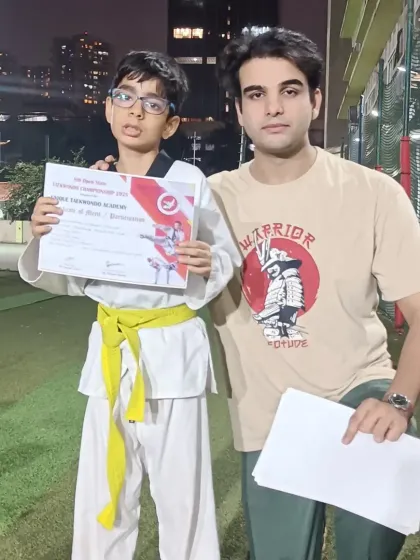 A student proudly holds his certificate after competing in the championship. The experience gained is as valuable as any medal.